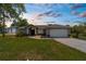Charming single story home with landscaped front yard, palm tree, and attached garage at 14031 Hexam Rd, Brooksville, FL 34613
