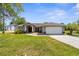 Charming single-story home with well-manicured lawn, attached garage, and inviting entrance at 14031 Hexam Rd, Brooksville, FL 34613