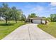 Wide driveway leading to a well-maintained home with green lawn and mature trees at 14031 Hexam Rd, Brooksville, FL 34613