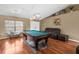 Spacious game room featuring a pool table, leather sofa, and hardwood floors at 14031 Hexam Rd, Brooksville, FL 34613