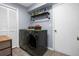Well-equipped laundry room with modern washer and dryer and stylish overhead shelving at 14031 Hexam Rd, Brooksville, FL 34613