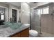 The main bathroom has a glass bowl sink, granite counters, and glass shower door, and access to a large closet at 14031 Hexam Rd, Brooksville, FL 34613