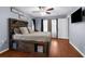 The main bedroom offers a custom bed frame, a flat-screen television, and warm wood-look floors, creating a cozy retreat at 14031 Hexam Rd, Brooksville, FL 34613