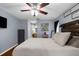 This main bedroom showcases a modern design with a dark wood bed frame, ceiling fan, and ensuite bathroom at 14031 Hexam Rd, Brooksville, FL 34613
