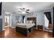Spacious main bedroom features a custom bed frame, ensuite bath, a ceiling fan, and natural light from two windows at 14031 Hexam Rd, Brooksville, FL 34613