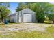 Large metal outbuilding with roll up door and side door; surrounded by grass and trees at 14031 Hexam Rd, Brooksville, FL 34613