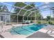 Sparkling screened pool with two lounge chairs and landscaped surroundings provides a relaxing retreat at 14031 Hexam Rd, Brooksville, FL 34613