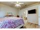 Bright bedroom with a doorway to ensuite bathroom and mounted television at 14466 Tamarind Loop, Spring Hill, FL 34609