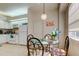 Bright dining area with a glass table, seating for four, and adjacent white kitchen at 14466 Tamarind Loop, Spring Hill, FL 34609