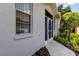 Charming home exterior featuring a screened door, window, and well-maintained landscaping at 14466 Tamarind Loop, Spring Hill, FL 34609