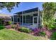 Rear of the home shows the screened-in lanai and mature landscaping at 14466 Tamarind Loop, Spring Hill, FL 34609