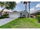 Charming single-story home featuring a well-manicured lawn and a two-car garage at 14466 Tamarind Loop, Spring Hill, FL 34609
