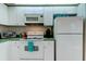Kitchen with white appliances and cabinets and tiled flooring at 14466 Tamarind Loop, Spring Hill, FL 34609