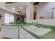 Kitchen area with green countertops and a sink overlooking a living room at 14466 Tamarind Loop, Spring Hill, FL 34609