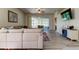 Comfortable living area boasts modern floors, a large sofa and a TV at 14466 Tamarind Loop, Spring Hill, FL 34609
