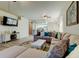 Bright living room with a large sectional sofa and view into the kitchen at 14466 Tamarind Loop, Spring Hill, FL 34609