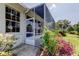 Side view of a screened in patio with access from the brick paved side of the home at 14466 Tamarind Loop, Spring Hill, FL 34609