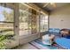 Relaxing sunroom with large windows, blue seating and a serene view at 14466 Tamarind Loop, Spring Hill, FL 34609