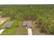 Aerial view of a home surrounded by lush greenery, showing the roofline, driveway, and surrounding landscape at 15414 Green Jay Rd, Weeki Wachee, FL 34614