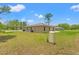 Expansive backyard featuring green grass and a large propane tank at 15414 Green Jay Rd, Weeki Wachee, FL 34614