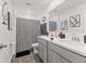 Bathroom with dual sinks, modern fixtures, and a black and white shower curtain at 15414 Green Jay Rd, Weeki Wachee, FL 34614
