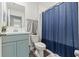 Well-lit bathroom with modern fixtures, a blue cabinet and shower curtain at 15414 Green Jay Rd, Weeki Wachee, FL 34614