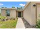 View of front door showcasing the walkway, front yard landscaping, and neutral-toned exterior at 15414 Green Jay Rd, Weeki Wachee, FL 34614