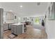 Modern kitchen featuring stainless steel appliances, an island with bar seating, and an open layout to living area at 15414 Green Jay Rd, Weeki Wachee, FL 34614