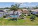 Aerial view of a house with a screened-in pool and a well-maintained backyard at 18223 Nestlebranch Ct, Hudson, FL 34667