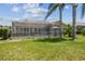 Backyard featuring a view of the screened-in pool and landscaped lawn at 18223 Nestlebranch Ct, Hudson, FL 34667