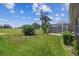 Large green backyard with grass and a view of the outdoor pool area at 18223 Nestlebranch Ct, Hudson, FL 34667