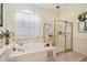 Well-lit bathroom featuring a soaking tub, glass-enclosed shower, and elegant fixtures at 18223 Nestlebranch Ct, Hudson, FL 34667