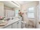 Bright bathroom features a tub with shower, window, and a decorative floral theme at 18223 Nestlebranch Ct, Hudson, FL 34667