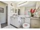 Bathroom vanity with floral decorations, large mirror and tile flooring at 18223 Nestlebranch Ct, Hudson, FL 34667