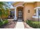 Close-up view of the home's inviting front entrance featuring double doors and manicured landscaping at 18223 Nestlebranch Ct, Hudson, FL 34667