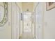 Hallway leading to the bathroom, featuring white doors and neutral decor at 18223 Nestlebranch Ct, Hudson, FL 34667