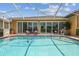 Backyard features a screened in pool, jacuzzi, and outdoor furniture at 18223 Nestlebranch Ct, Hudson, FL 34667