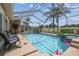 Screened in pool with jacuzzi and lounge seating overlooking the golf course at 18223 Nestlebranch Ct, Hudson, FL 34667
