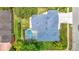 Aerial view of a home featuring a pool and a screened enclosure, surrounded by lush landscaping at 18902 Saint Laurent Dr, Lutz, FL 33558