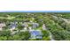Aerial view showcasing a home with a screened pool, mature trees, and proximity to a golf course and major highway at 18902 Saint Laurent Dr, Lutz, FL 33558