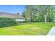 Large backyard featuring a well-manicured lawn, mature trees, and black metal fence at 18902 Saint Laurent Dr, Lutz, FL 33558