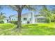 Private backyard with mature tree, screened pool enclosure, and well-maintained lawn at 18902 Saint Laurent Dr, Lutz, FL 33558