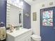 Coastal bathroom with a white vanity, stylish decor, and a colorful stained-glass window for a unique touch at 18902 Saint Laurent Dr, Lutz, FL 33558
