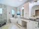Modern bathroom featuring a soaking tub, marble shower, and double vanity at 18902 Saint Laurent Dr, Lutz, FL 33558