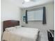 Bright bedroom with a large window, ceiling fan, and neutral decor, creating a calm and inviting space at 18902 Saint Laurent Dr, Lutz, FL 33558