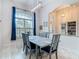Elegant dining room with a large window, blue curtains, modern chandelier, and seating for six at 18902 Saint Laurent Dr, Lutz, FL 33558