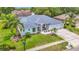 Charming single-story home with manicured lawn, palm trees, and a three-car garage at 18902 Saint Laurent Dr, Lutz, FL 33558