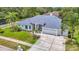 Charming single-story home with manicured lawn, palm trees, and a three-car garage at 18902 Saint Laurent Dr, Lutz, FL 33558