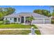 Charming single-story home with manicured lawn, palm trees, and a three-car garage at 18902 Saint Laurent Dr, Lutz, FL 33558