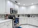 Well-appointed kitchen with stainless steel appliances, white cabinets, and a decorative tile backsplash at 18902 Saint Laurent Dr, Lutz, FL 33558